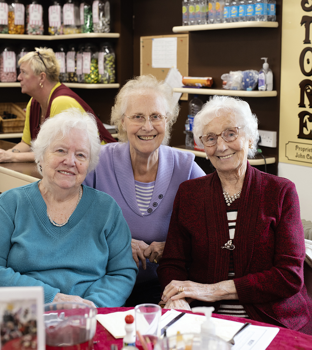 three senior women smiling for a photo